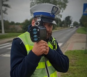 policjant wydziału ruchu drogowego podczas mierzenia prędkości wideorejestratorem