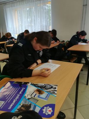 uczniowie w klasie przy stołach piszący test wiedzy