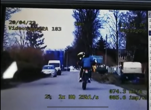 kierujący w kasku na motocyklu poruszający się po ulicy