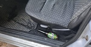 fotel kierowcy, pod fotelem butelka po alkoholu