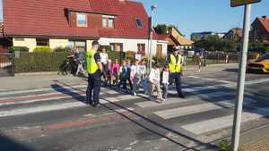 grupa dzieci, umundurowani policjanci, przejście dla pieszych, droga