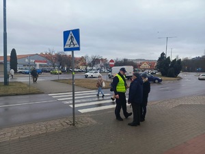 umundurowany policjant, przechodnie-osoby na drodze