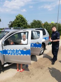 oznakowany radiowóz i policjant na festynie