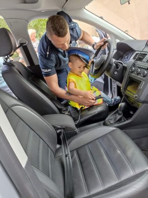 policjant i dziecko w radiowozie policyjnym