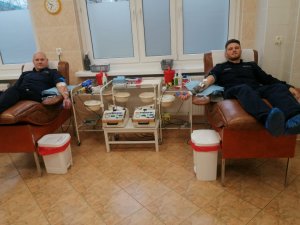 dwóch umundurowanych policjantów oddających krew