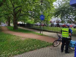Umundurowany policjant, rowerzysta, rower na ścieżce rowerowej