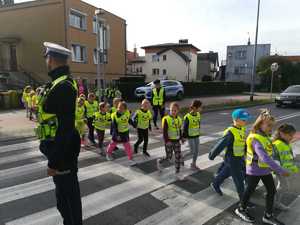 umundurowani policjanci wraz z dziećmi na przejściu dla pieszych