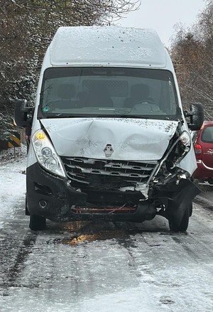uszkodzony przód białego pojazdu typu bus na drodze pokrytej śniegiem