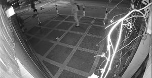 czarno-białe zdjęcie z zapisu z monitoringu - osoba na chodniku