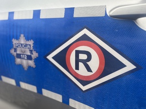 bok oznakowanego radiowozu, logo ruchu drogowego i gwiazda policyjna
