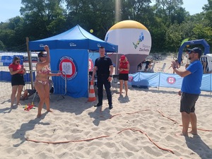 plaża, umundurowani funkcjonariusze, grupa dzieci i dorosłych